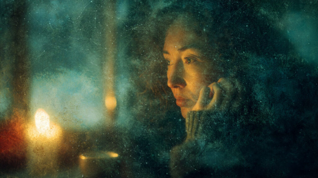 Woman gazing out a window at the January Full Moon, reflecting on spiritual growth and intuition.